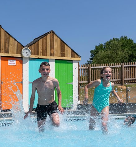 Young boy and girl running in outside Finlake pool